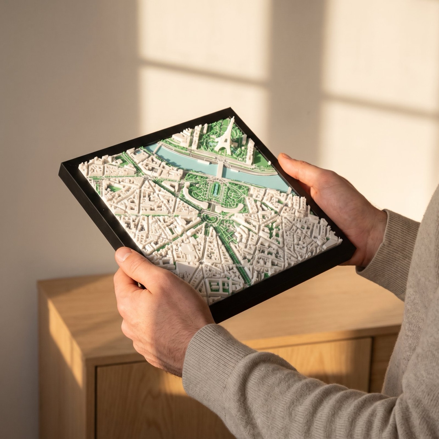 Hands holding a framed 3D city model